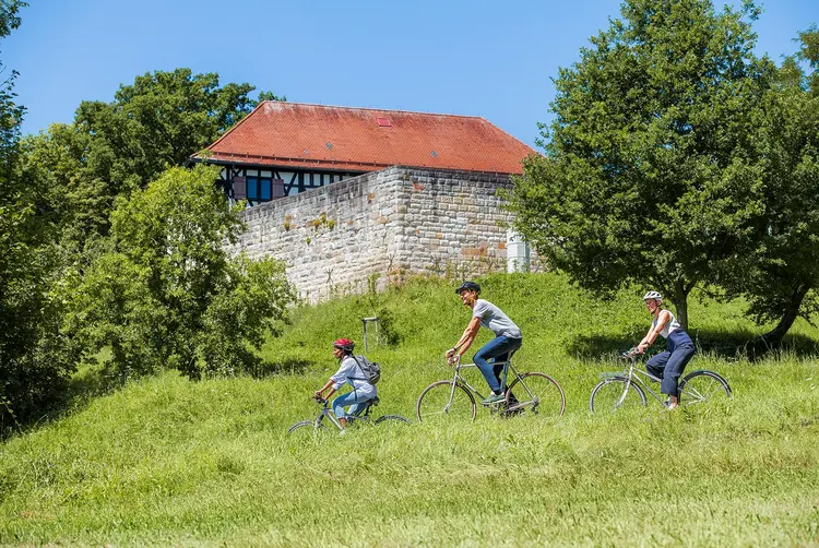 Foto: Staatliche Schlösser und Gärten Baden-Württemberg, Niels Schubert Burg Wäscherschloss, Radfahrer vor der Burg